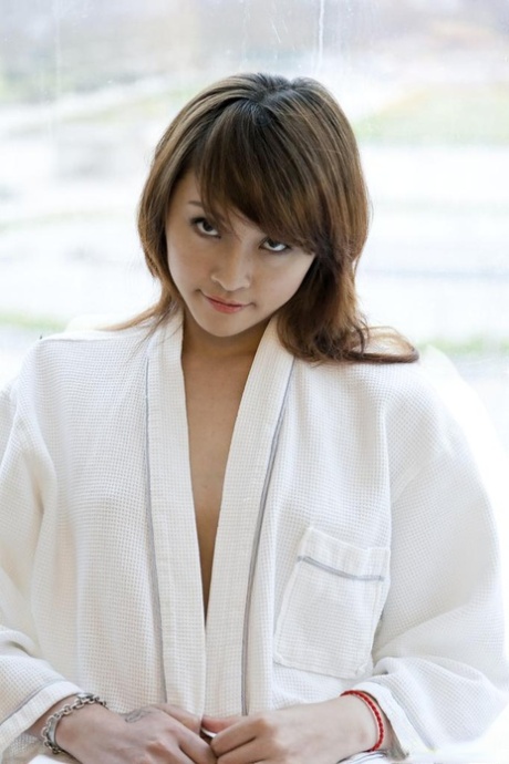 Petite Asian teen Lavinia Chan doffs a robe to pose naked on a window sill