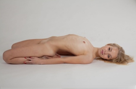 Slim blonde teen with tiny tits Estel K removes panties to model totally naked