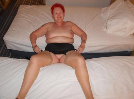 Fat redhead nan Valgasmic Exposed poses nude on a bed in tan nylons and heels