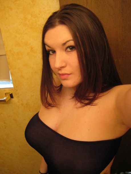 Curvy girl takes self shots in a mirror while wearing an off shoulder dress