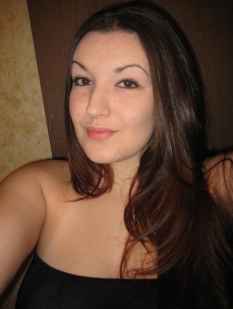 Curvy girl takes self shots in a mirror while wearing an off shoulder dress