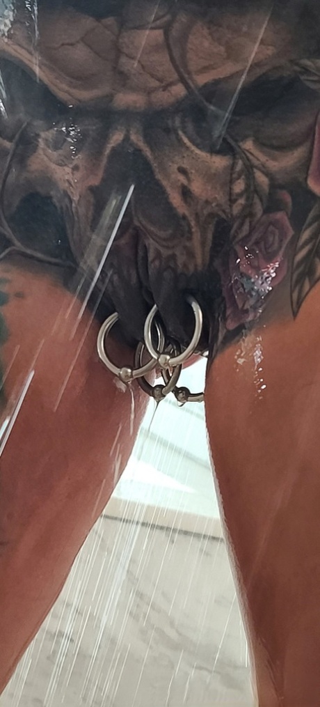 Tatted older woman Marie Bossette highlights her pierced pussy while showering