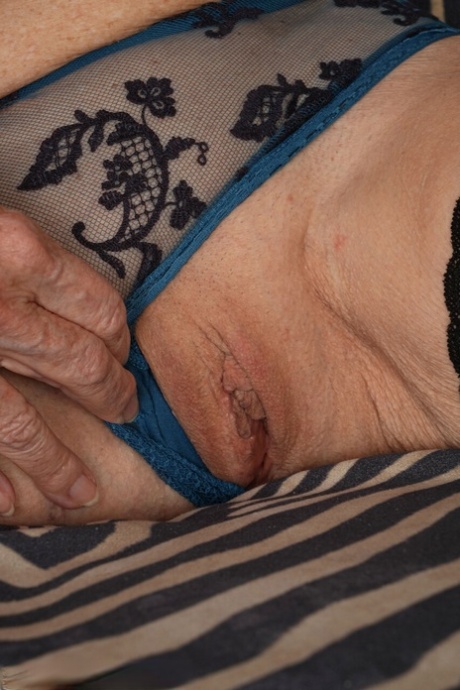 Mature woman Romana B finger spreads her shaved pussy in stockings