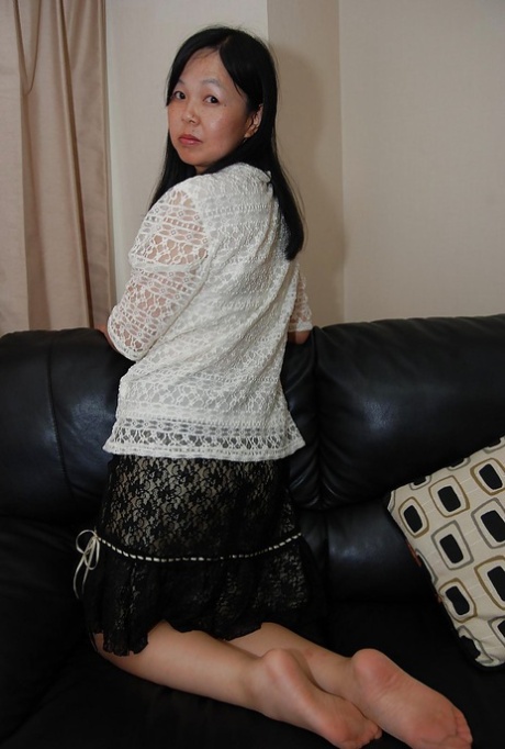 Mature Asian female undresses and introduces her hairy beaver