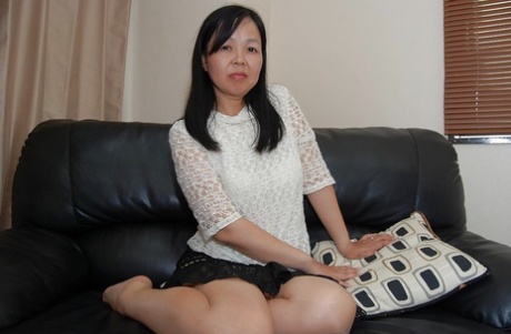 Mature Asian female undresses and introduces her hairy beaver