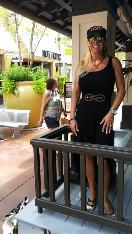 Sweet housewife Sandra Otterson poses in sexy glasses and tight skirt