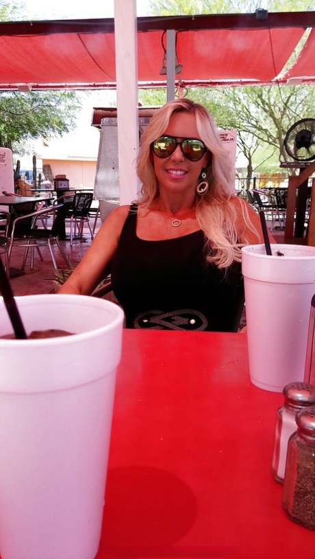 Sweet housewife Sandra Otterson poses in sexy glasses and tight skirt