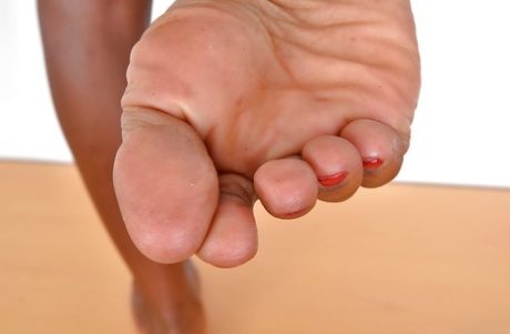 Older black woman showing off sexy legs and painted toenails