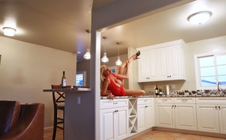 Blonde cougar with huge tits Kelly Madison flashes her twat in the kitchen