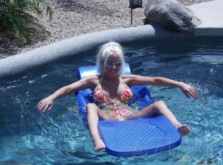 Skinny blonde with huge fake boobs Kelly Erikson shows her cunt in the pool