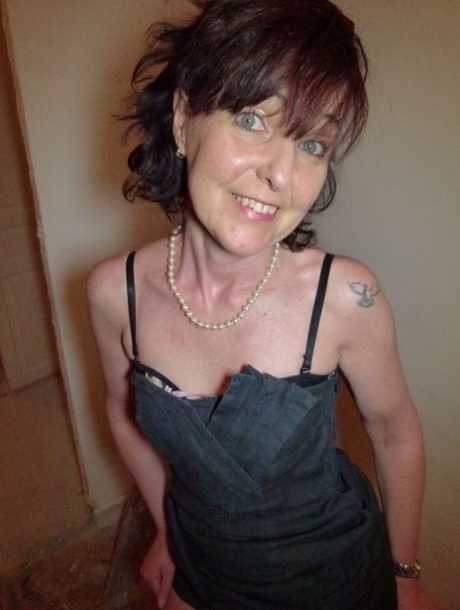 Mature brunette Joyce Mifle strips her clothes & poses in her lingerie