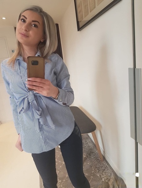Amateur blonde Ari Fox reveals her small boobs and poses in front of a camera