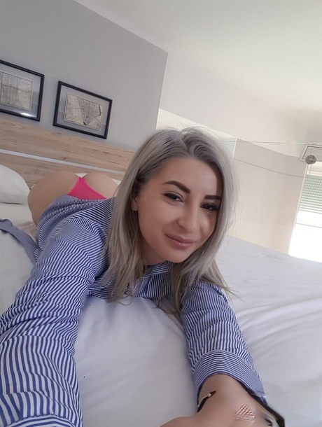 Amateur blonde Ari Fox reveals her small boobs and poses in front of a camera