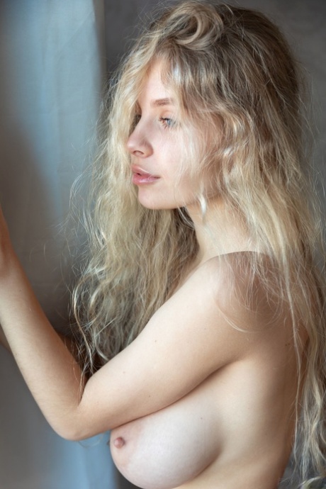 Petite teen Mila Amour flaunts her big tits in a stunning lingerie striptease