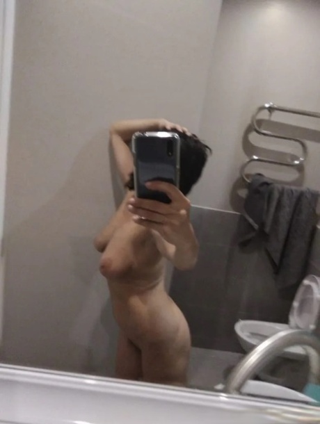 Mature brunette takes nude selfies in the bathroom showing her saggy tits