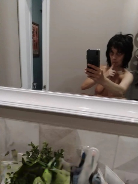 Mature brunette takes nude selfies in the bathroom showing her saggy tits