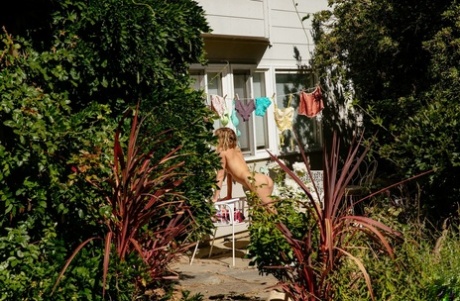 Blonde River strips naked and sunbaths her hot body with hanging laundry