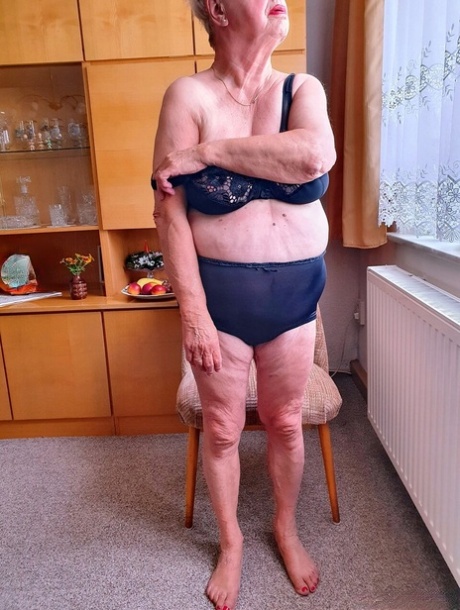 Short-haired granny Alma exposes her big saggy tits while changing