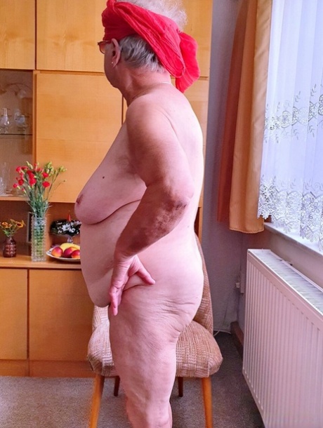 Short-haired granny Alma exposes her big saggy tits while changing