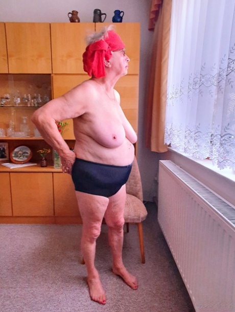 Short-haired granny Alma exposes her big saggy tits while changing
