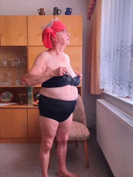 Short-haired granny Alma exposes her big saggy tits while changing