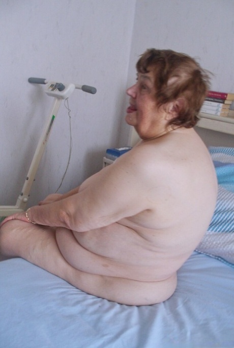 Tall redheaded granny Kurra loses her white lingerie and shows her saggy tits