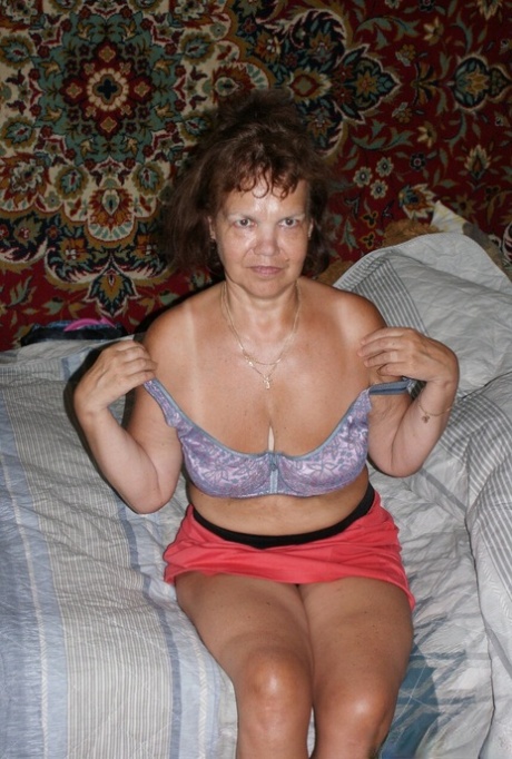 Curly-haired granny Oma Geil unleashes her big saggy tits and rubs her cunt