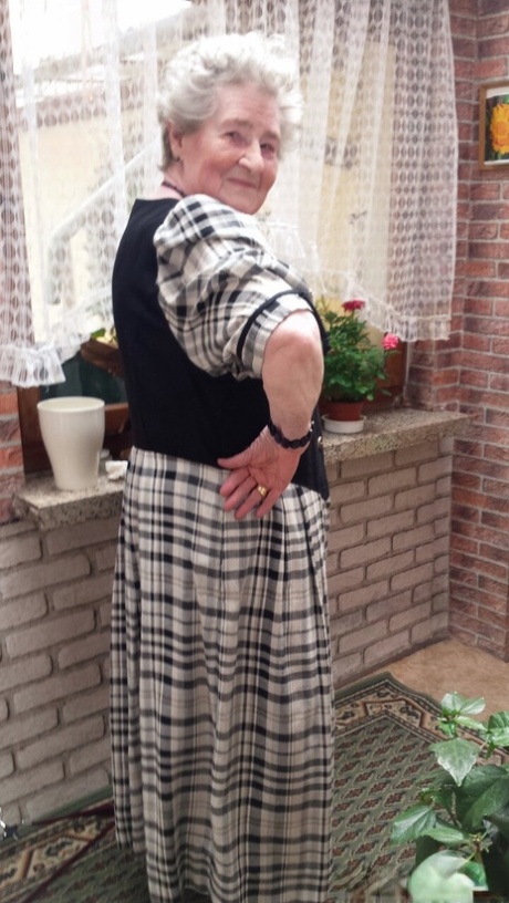 Short-haired granny Pitschka undressing and showing her saggy boobs